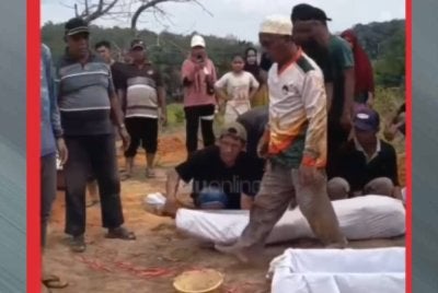 Jasad kemudian diberikan kain kafan baharu sebelum dipindahkan ke kubur baharu untuk dikebumikan semula.-Foto Riau Online