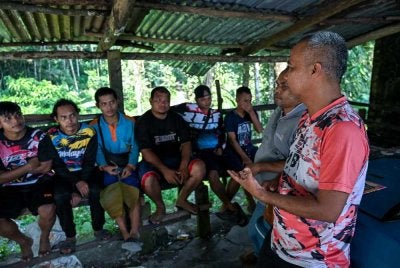 Chew Ho Beng (kanan) bersama sebahagian daripada 22 sukarelawan Orang Asli membuat persiapan sebelum memulakan pendakian bagi misi mencari pendaki, Jaslinda Saludin, 49, yang dilaporkan hilang di Gunung Batu Putih sejak Ahad lalu, ketika tinjauan di Kampung Ampang Woh. Foto fail Bernama