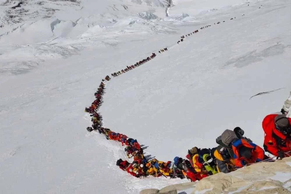 Laluan pendakian sesak dengan kumpulan pendaki yang beratur panjang di kawasan bersalji berhampiran puncak sambil menunggu giliran untuk meneruskan misi menawan puncak Everest.