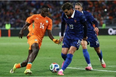 Penyerang Ivory Coast, Oumar Diakite (kiri) cuba mengelecek pertahanan Perancis, Theo Hernandez ketika aksi persahabatan menjelang Piala Dunia 2026. - Foto: AFP