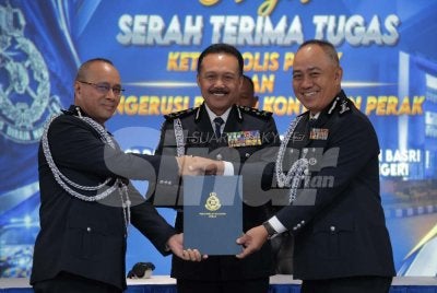 Mohd Yusri (tengah) menyaksikan pertukaran dokumen serah terima tugas di antara Noor Hisam (kiri) dengan Mohd Alwi yang berlangsung di Mes Pegawai Kanan PDRM Perak pada Jumaat.