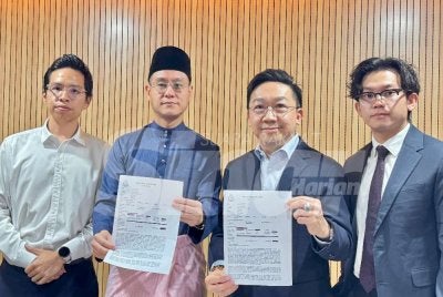 Bryan (dua dari kanan), Dixon (kanan) dan Zairil (dua dari kiri) menunjukkan laporan polis yang dibuat pada 29 Mei lalu.