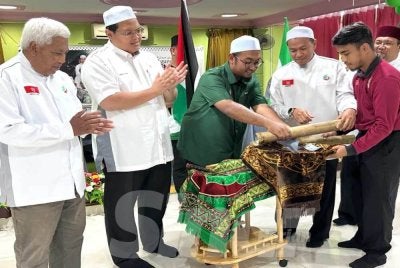 Dr Tengku Muhammad Fakhruddin (tengah) diiringi Muhamad Faruqi (dua dari kanan) memecahkan tabung buluh sebagai simbolik perasmian. Foto Adila Sharinni Wahid