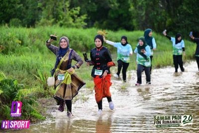 Tengku Rosmaini (kiri) berlari dalam sawah dengan memakai sari.
Foto ihsan DR SPOT EVENT