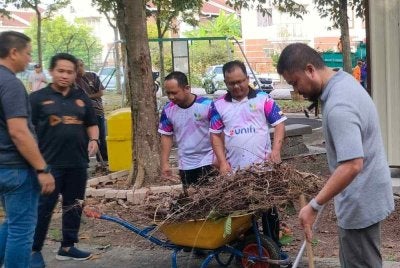 Akmal Zharif (kanan) bersama-sama penduduk menjayakan Program Gotong-Royong Perdana Taman Meru Perdana 2 pada Sabtu.