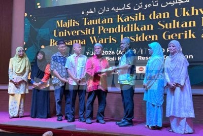 Azman (lima dari kiri) menyerahkan naskhah al-Quran tulisan tangan Allahyarham Nurly Sahirah kepada pihak UPSI yang diterima oleh Md Amin (tiga dari kanan) sebagai simbolik majlis. Foto: ADILA SHARINNI WAHID