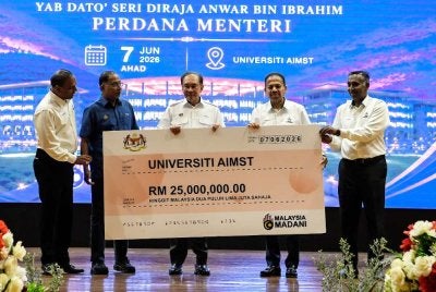 Anwar (tengah) menyerahkan mock cheque kepada Canselor Universiti AIMST, Tan Sri Dr SA Vigneswaran pada Majlis Serahan Pemberian Geran Kerajaan Tahunan kepada Universiti AIMST pada Ahad. Foto: Bernama 