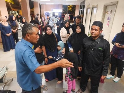 Adzli (kiri) menziarahi keluarga mangsa kemalangan di Jabatan Forensik Hospital Sultanah Bahiyah di Alor Setar pada Ahad malam.
