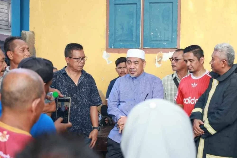 Dr Izani (tengah) turun padang bertanyakan khabar kepada mangsa kebakaran di Kampung Cina, Gok Kapur, Kota Bharu pada tengah hari Isnin.Foto:ADUN KIJANG