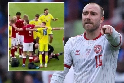 Pemain kedua-dua pasukan membentuk bulatan bagi melindungi Eriksen yang rebah di atas padang. FOTO: Agensi