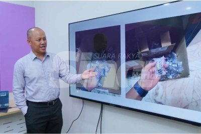 Ethan menunjukkan botol minyak tiruan yang dirampas pihak berkuasa. - Foto SINAR HARIAN / MOHD HALIM ABDUL WAHID