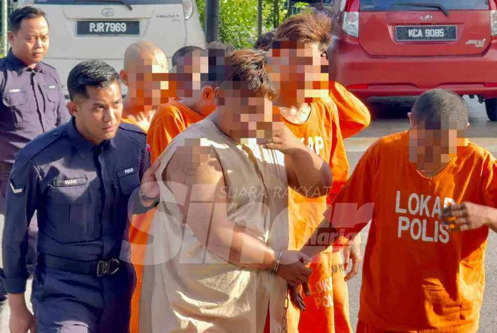 Suspek (tengah) yang memakai baju lokap dibawa ke Mahkamah Majistret Bukit Mertajam pada pagi Selasa.