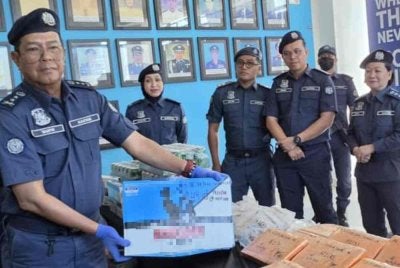 Ahmad Taufik (kiri) menunjukkan antara minuman keras yang dirampas JKDM Sabah dalam sidang akhbar di Menara Kastam Kota Kinabalu