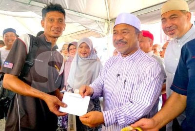 Mohd Nassuruddin (dua,kanan) dan Dr Izani (kanan) menyampaikan bantuan kepada mangsa kebakaran di Kampung Cina, Gok Kapur, Kota Bharu pada Selasa. Foto: HAZELEN LIANA KAMARUDIN