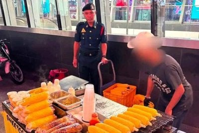 Anggota penguat kuasa DBKL menjalankan tindakan penguatkuasaan terhadap seorang penjaja jagung bakar di Jalan Bukit Bintang di sini pada Ahad lalu.