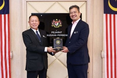 Abd Halim (kiri) menyerahkan cenderahati kepada Johan ketika kunjungan hormat di MOF pada Selasa. Foto SPRM