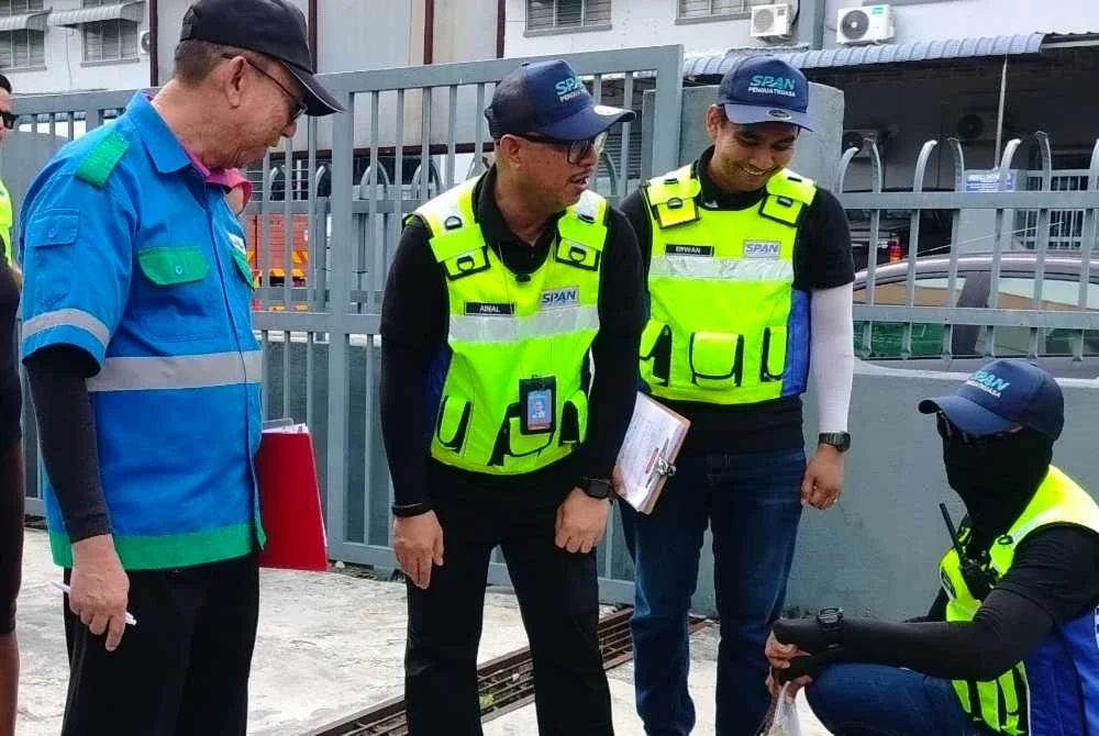 Ainal Yusman (tengah) meninjau tangki septikketika Ops Kejor oleh SPAN di Kawasan Perindustrian Menglembu pada Rabu.