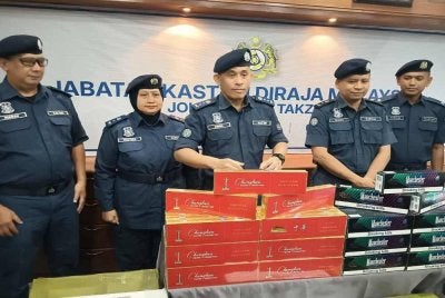 Aminul Izmeer ( tengah) menunjukkan rokok putih yang dirampas pada sidang akhbar di Menara Kastam Johor Bahru.