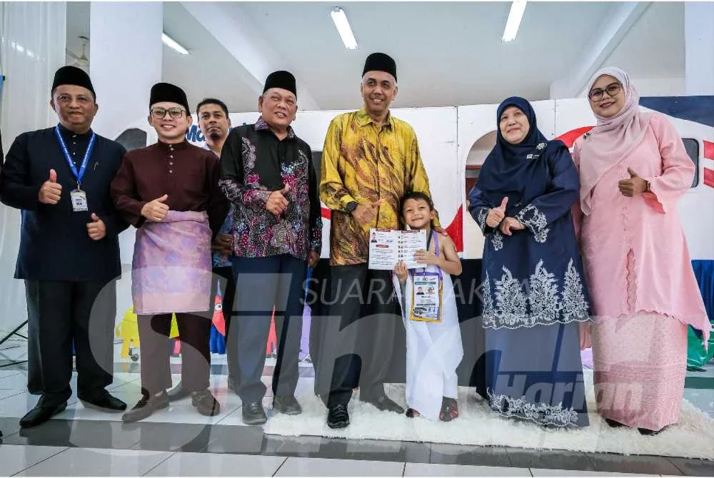 Khairudin (tiga dari kanan) menyerahlan replika passport sebagai simbolik perjalanan haji peserta Program Kecemerlangan Pendidikan Simulasi Haji Generasi Alpha di Masjid Sultan Yussuf Izzuddin Shah, Seri Iskandar pada Khamis.