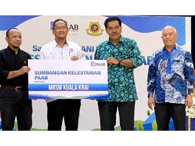Ir Jaseni (dua dari kanan) menyerahkan replika cek sumbangan peruntukan RM50,000 kepada Ismail (dua dari kiri) bagi menaik taraf kemudahan berkaitan penggunaan air di MRSM Kuala Krai menerusi program CSR Santuni MADANI. 