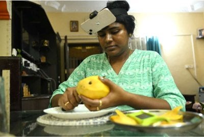 Sriramyachandra memakai sebuah telefon pintar di kepalanya ketika merakam pergerakannya melalui tangkapan gerakan semasa menghiris mangga di rumahnya di Chennai.