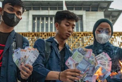 Mahasiswa membakar wang kertas tiruan semasa protes di Semarang, Jawa Tengah bagi membantah kejatuhan nilai rupiah yang berulang kali mencatat paras terendah berbanding dolar Amerika Syarikat sejak beberapa minggu kebelakangan ini. - Agensi