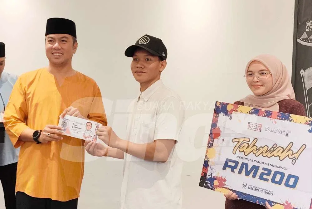 Khairul Anwar menyampaikan hadiah kepada Muhammad Azmi yang menang dalam pertandingan Karya Anak Pahang pada Majlis Penyampaian Hadiah Pertandingan Karya Anak Pahang di Unit Komunikasi Strategik pada Jumaat.