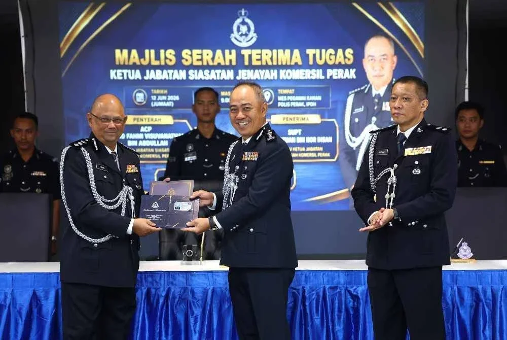 Mohd Alwi menyerahkan kad persaraan kepada Asisten Komisioner Mohd Fahmi Visuvanathan Abdullah yang telah bersara wajib.