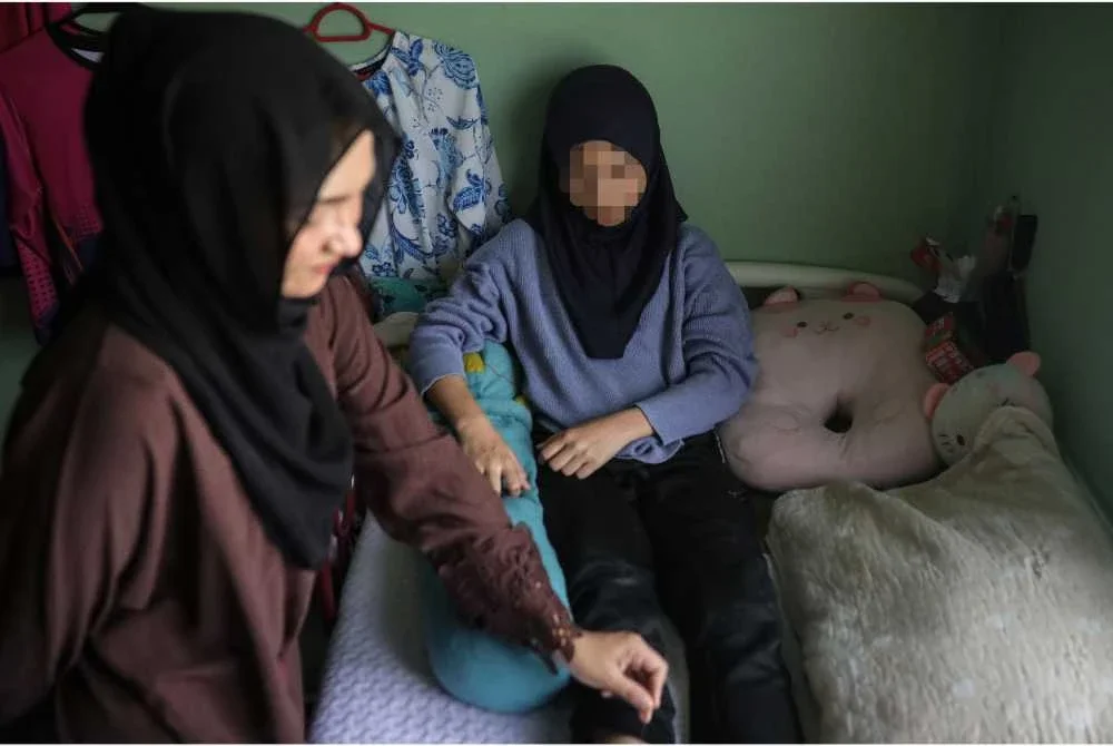 Norasikin menguruskan anak perempuannya berusia 12 tahun kini mengalami keterbatasan pergerakan sehingga tidak dapat bersekolah hampir 4 bulan selepas dipercayai terjatuh akibat kerusi yang ingin didudukinya ditarik oleh rakan sekelas dalam kejadian pada 11 Februari lepas di sebuah sekolah dekat Chuping. - Foto: Bernama