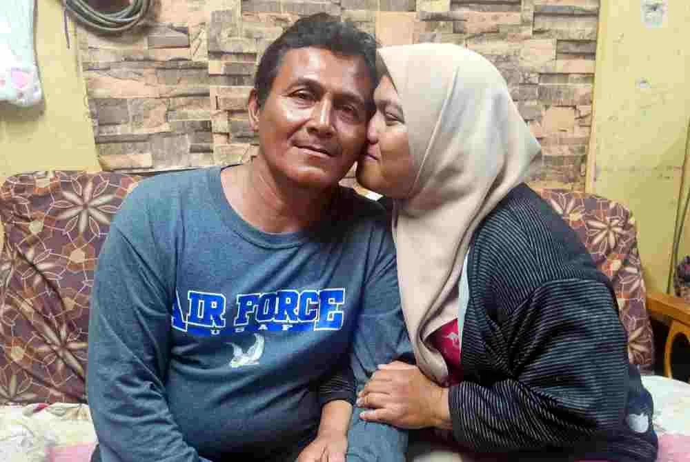 Mahadi dicium isterinya, Wan Siti Aisyah selepas terselamat dalam kejadian bot tenggelam di perairan Kemaman pada Rabu lepas ketika ditemui di Perumahan Rakyat Fikri, hari ini. Foto Bernama