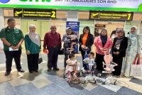 Siew Khim (empat dari kanan) menyerahkan tiga kanak-kanak warga Indonesia kepada Nelvy (empat dari kiri) di Lapangan Terbang Antarabangsa Pulau Pinang pada Jumaat.