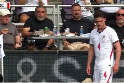 Peminat dilihat menikmati burger di meja makan tepi padang ketika pemain tengah England, Declan Rice bersedia mengambil sepakan sudut. - Foto: Agensi