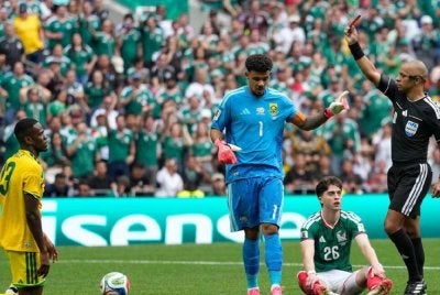 Sithole (kiri) dilayangkan kad merah oleh pengadil perlawanan dalam penampilan sulungnya di pentas Piala Dunia. Foto: Agensi