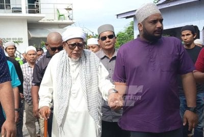 Abdul Hadi dipimpin selepas menyampaikan kuliah
Duha di Masjid Rusila, Marang pada Jumaat.