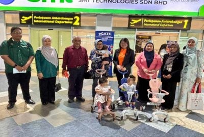 Siew Khim (empat dari kanan) menyerahkan tiga kanak-kanak warga Indonesia kepada Nelvy (empat dari kiri) di Lapangan Terbang Antarabangsa Pulau Pinang pada Jumaat.