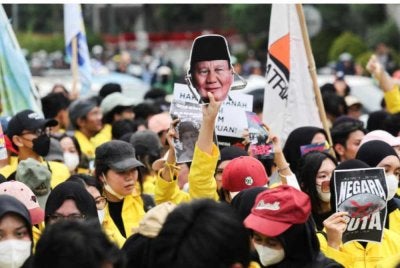 Seorang pelajar mengangkat topeng wajah bergambar Presiden Indonesia, Prabowo Subianto, ketika menyertai protes membantah beberapa dasar kerajaan termasuk perbelanjaan belanjawan negara, kenaikan harga bahan api, program makanan percuma dan peluasan peranan tentera dalam urusan awam di Jakarta pada 12 Jun 2026. - Agensi