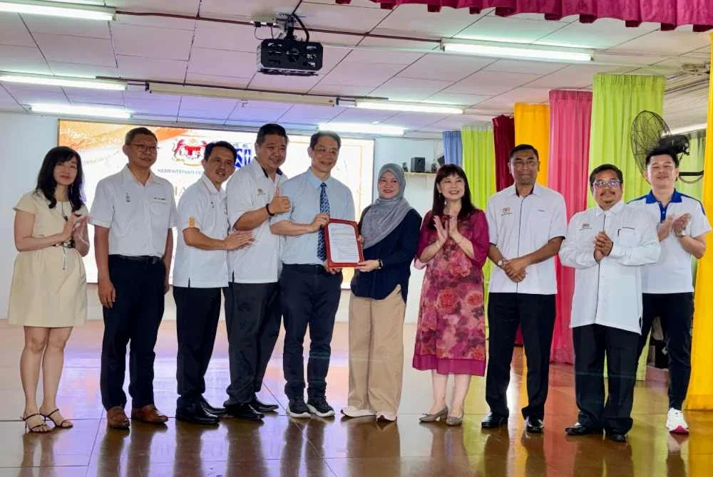 Fadhlina (lima dari kanan) menyerahkan surat kelulusan pembinaan bangunan baharu Sekolah Jenis Kebangsaan Cina Heng Ee pada Sabtu.