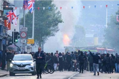 Sebuah bas terbakar ketika sekumpulan penunjuk perasaan berkumpul di Jalan Newtownards, timur Belfast. Foto AFP