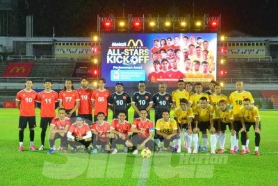 Pasukan Selebriti (kiri) bergambar kenangan bersama bekas pemain kebangsaan sebelum sepak mula Program Mekdi All Stars Kick Off: Perlawanan Amal RMHC Malaysia di Stadium Merdeka pada Jumaat. Foto Sinar Harian - ASRIL ASWANDI SHUKOR