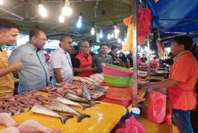 Ahmad Badli Shah (empat dari kiri) memberi penerangan mengenai kemudahan pembiayaan mikro yang ditawarkan DFI ketika program turun padang di Pasar Tani Bandar Tasik Permaisuri, Cheras, Kuala Lumpur pada Sabtu.