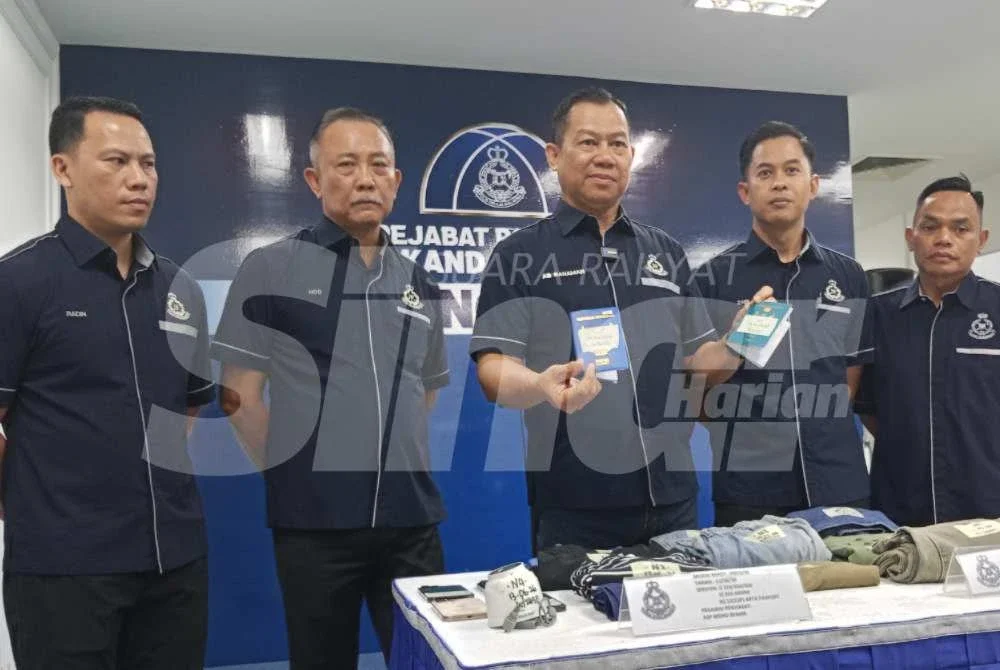 Ab Rahaman (tengah) menunjukkan pasport mangsa yang dirampas daripada suspek.- Foto SINAR HARIAN/NOR AZURA MD AMIN