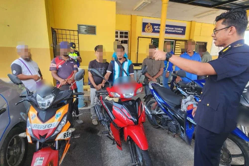 Mohd Zamri (kanan) menunjukkan antara kenderaan yang disita dan warga asing yang ditahan dalam Ops PEWA di Terengganu.