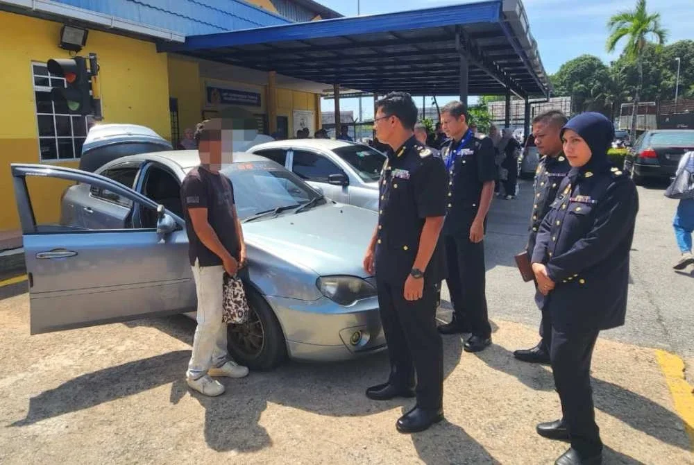 Zamri (tengah) melihat kenderaan yang disita dan warga asing yang ditahan dalam Ops PEWA di Terengganu.