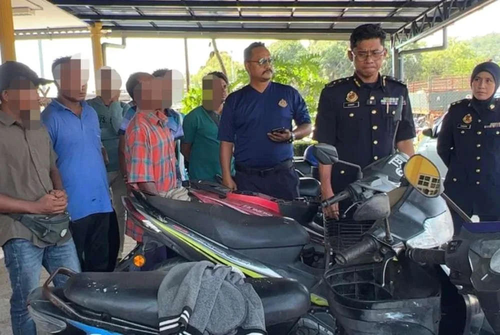 Zamri (dua dari kanan) meninjau kenderaan yang disita dan warga asing yang ditahan dalam Ops PEWA di Terengganu.