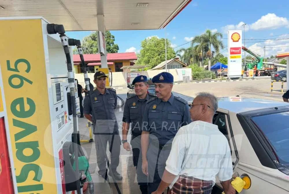 Hanif Yusabra (dua, kanan) melakukan pemantauan di stesen minyak di sempadan di Tumpat.