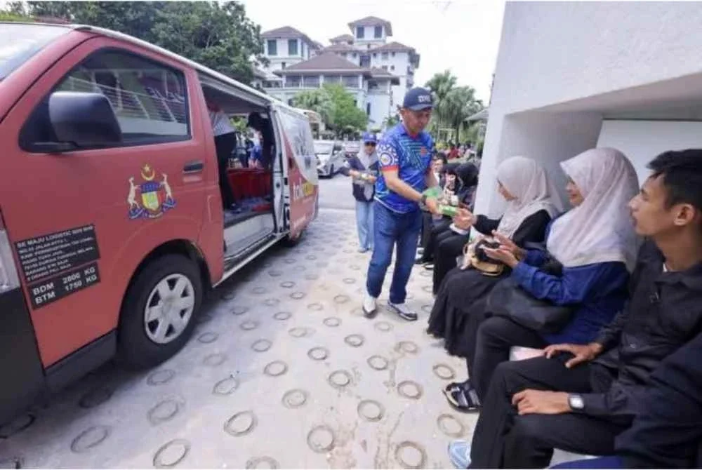 Shadan agihkan makanan kepada calon hadir temu duga terbuka kilang elektronik pada Ahad. Foto FB Datuk Shadan Othman