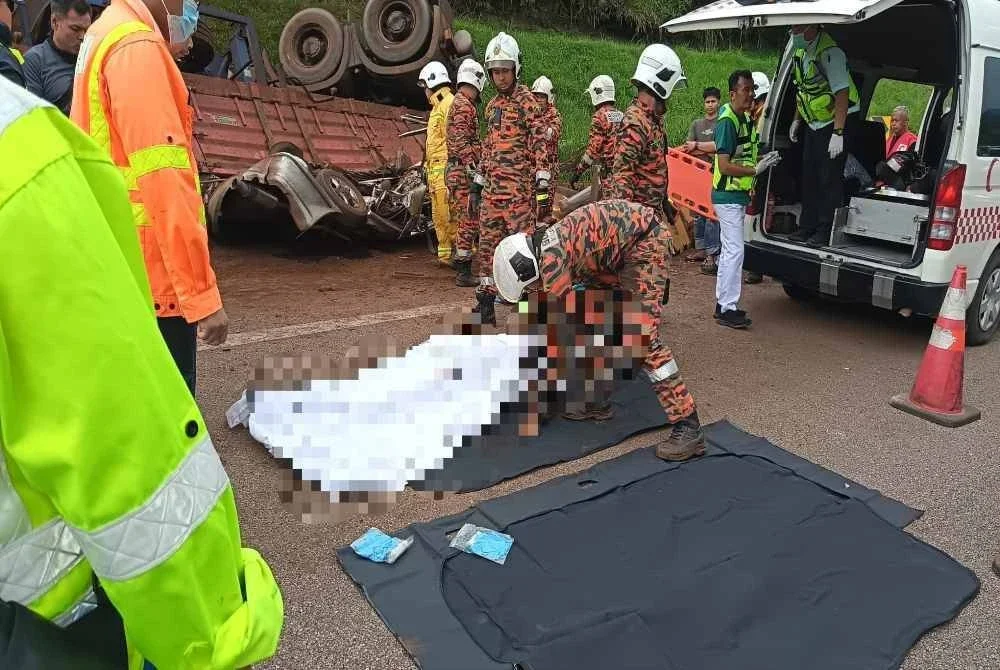 Anggota bomba mengeluarkan salah seorang mangsa yang maut sebelum diserahkan kepada polis untuk tindakan lanjut.