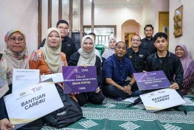 Zambry (depan, tengah) Norliza (depan, tiga dari kiri) bergambar bersama penerima Biasiswa Anak e-Kasih (BAeK) PTPTN, Muhammad Amar Khoo (dua dari kanan) dan Alin Nairen Wong (dua dari kiri), pada Sesi Penyerahan Biasiswa Anak e-Kasih PTPTN di Kulai. Foto Bernama 