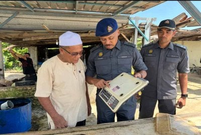Hanif Yusabra (tengah) memberi penerangan kepada peniaga ayam supaya memastikan penimbang tidak tamat tempoh.
FOTO: ADILA SHARINNI WAHID
