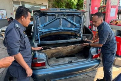 Hanif Yusabra (kanan) memeriksa bahagian tangki yang diubah suai. Foto KPDN